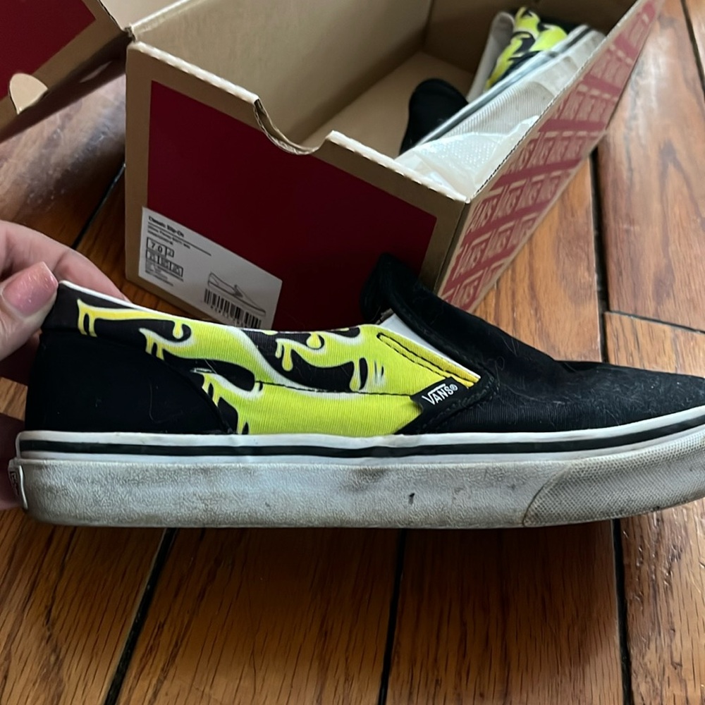 Heavily worn Vans slip on sneakers